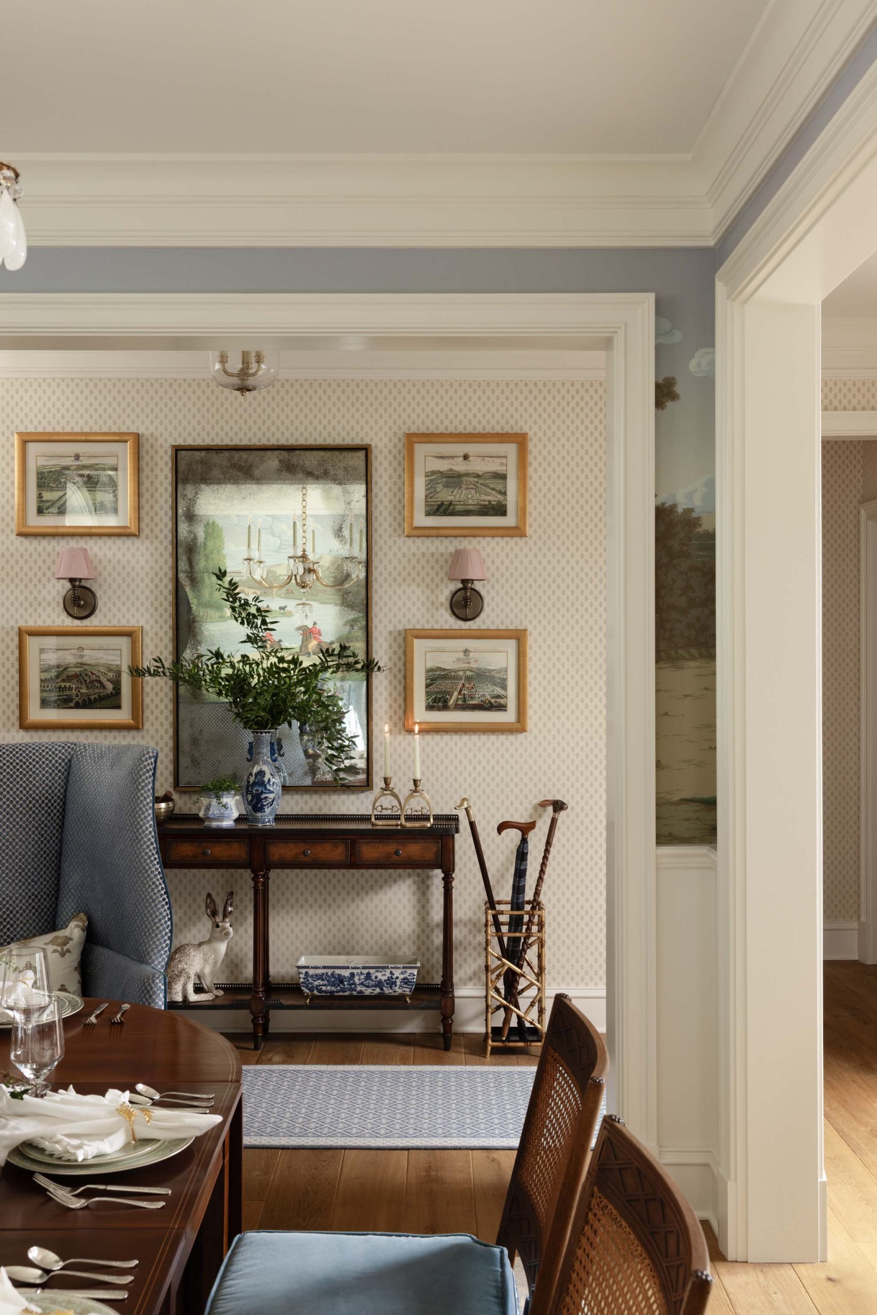 Traditional English foyer with antique mirror, console table and collected artwork