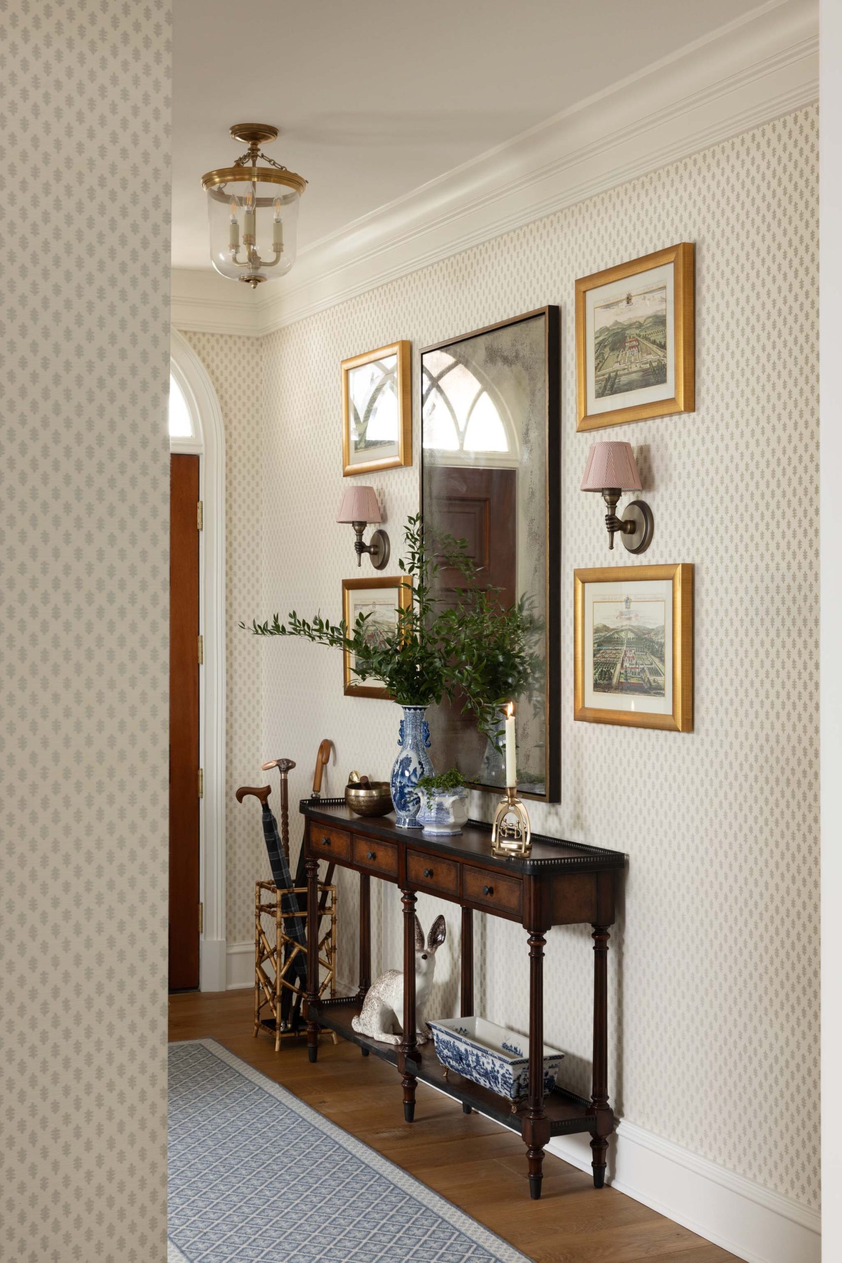 Traditional English foyer with antique furniture and collected artwork
