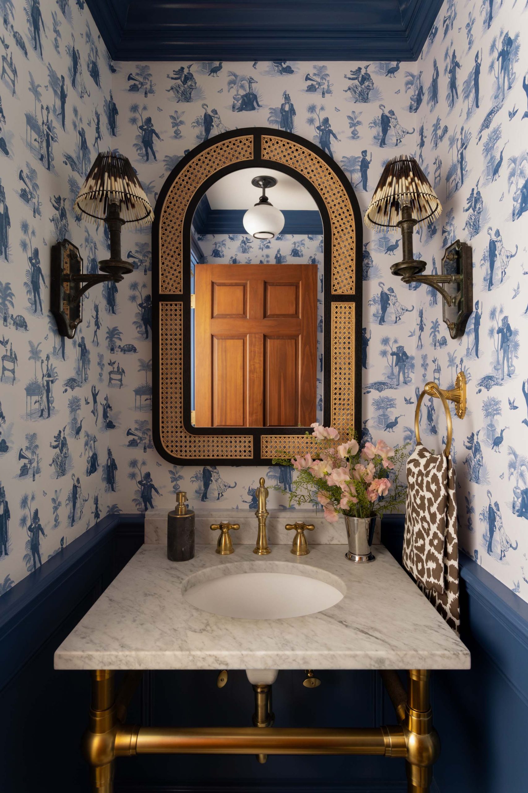 Traditional English powder room with blue toile wallpaper and lacquered blue millwork