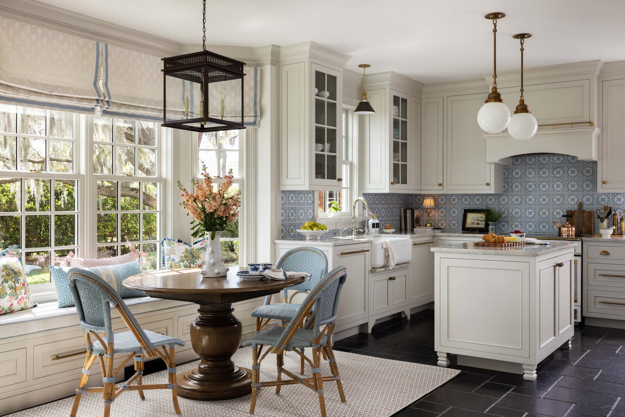 English country kitchen with custom cabinetry, breakfast nook and hand-painted blue tile backsplash