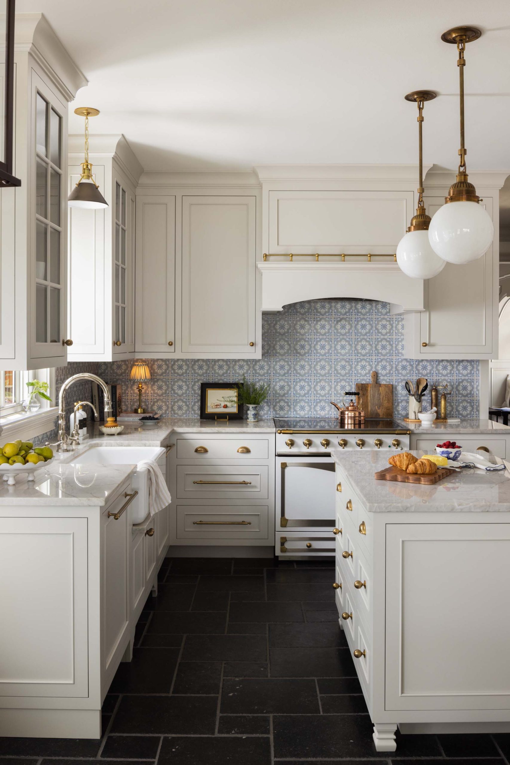 English country kitchen with farmhouse sink, brass range and marble countertops