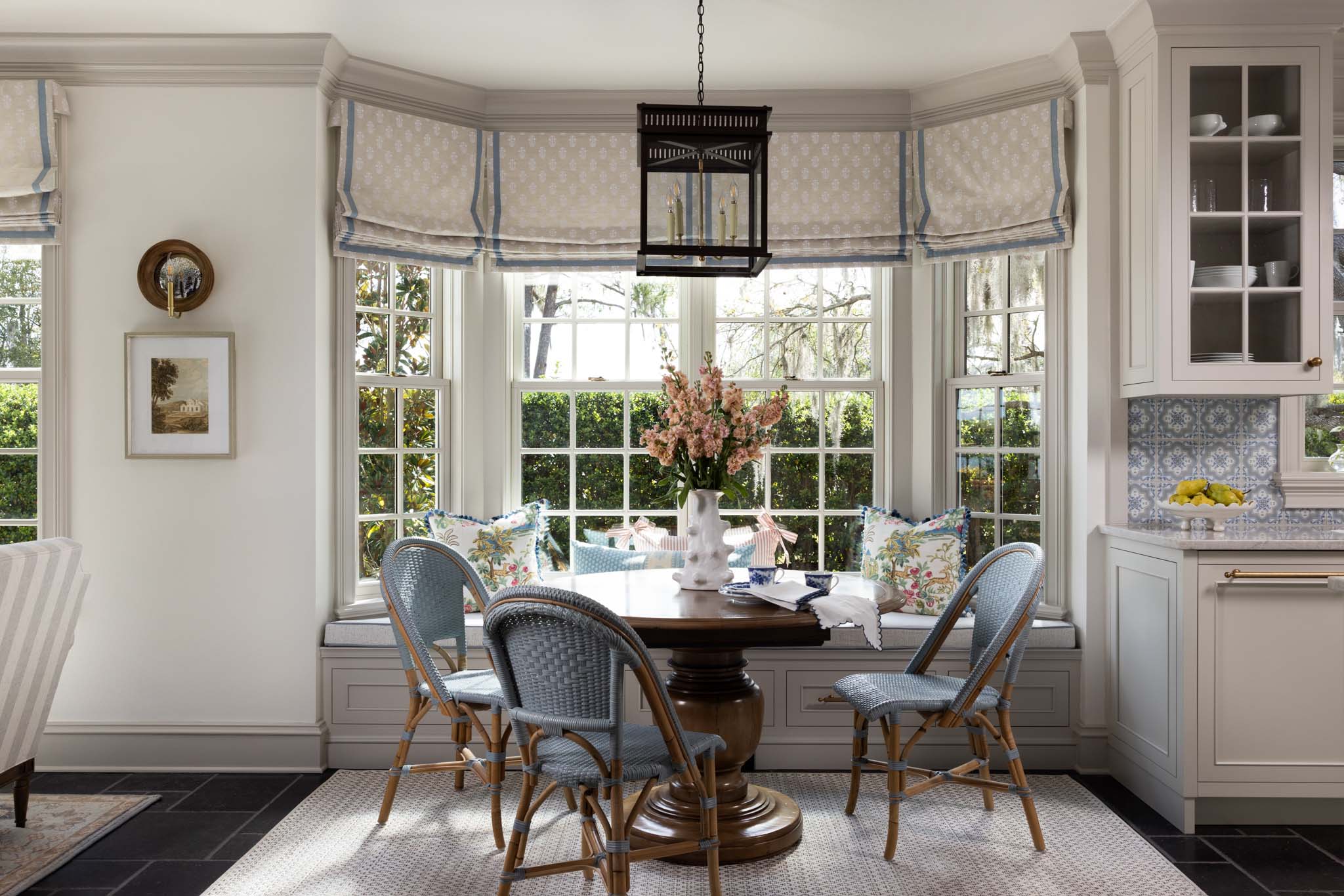English country breakfast nook with bay window, built-in banquette and Roman shades
