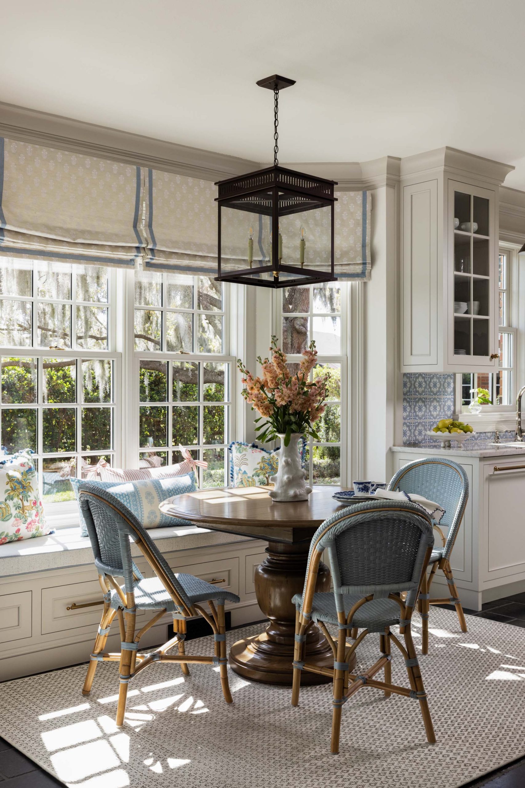 English country breakfast nook with woven bistro chairs and lantern pendant