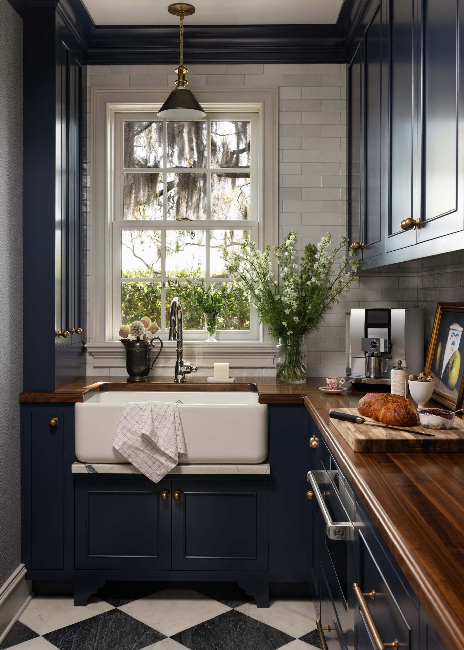 Traditional English scullery with navy inset cabinetry, farmhouse sink and walnut countertops