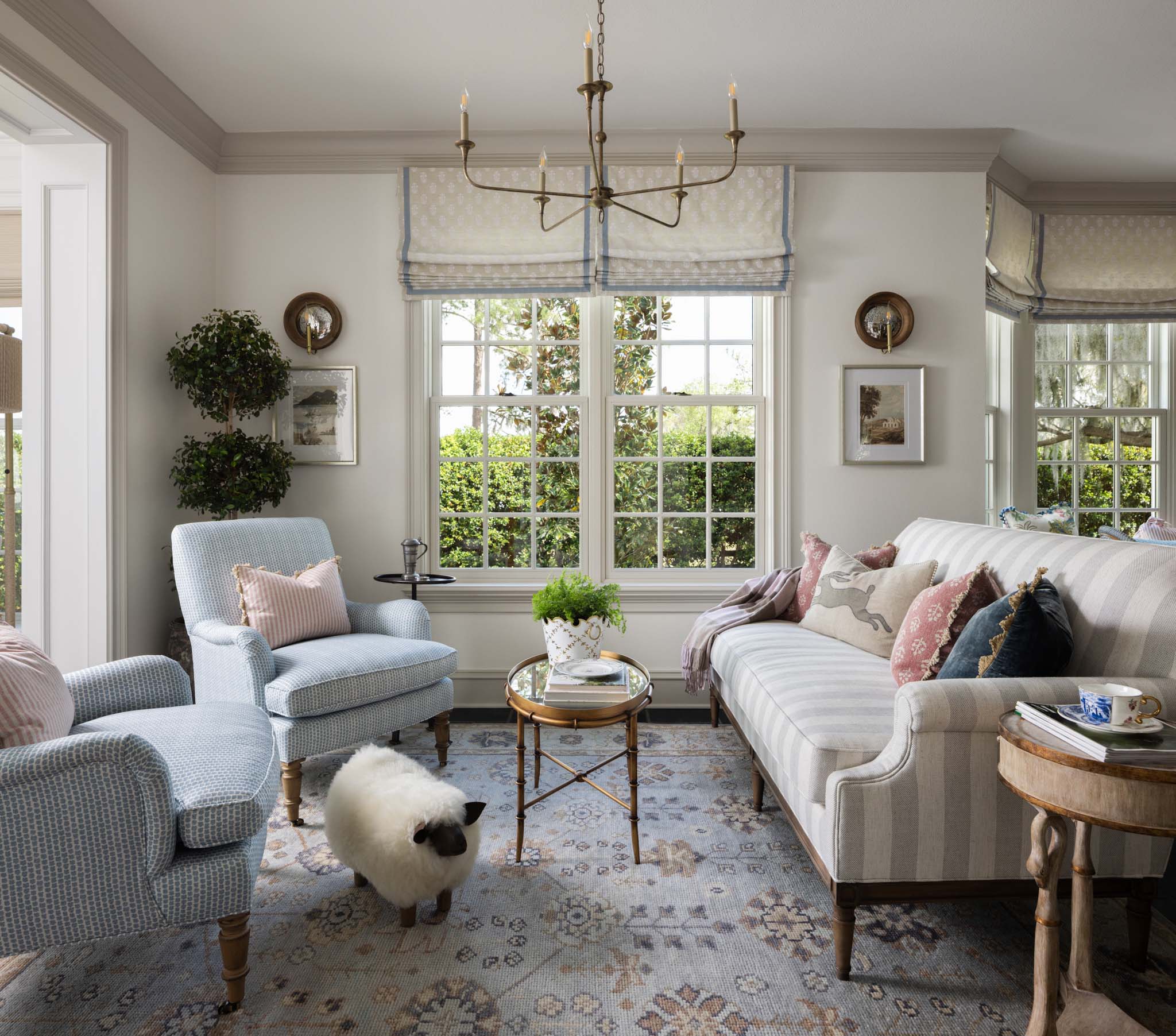 English country living room with blue and white furnishings and custom Roman shades