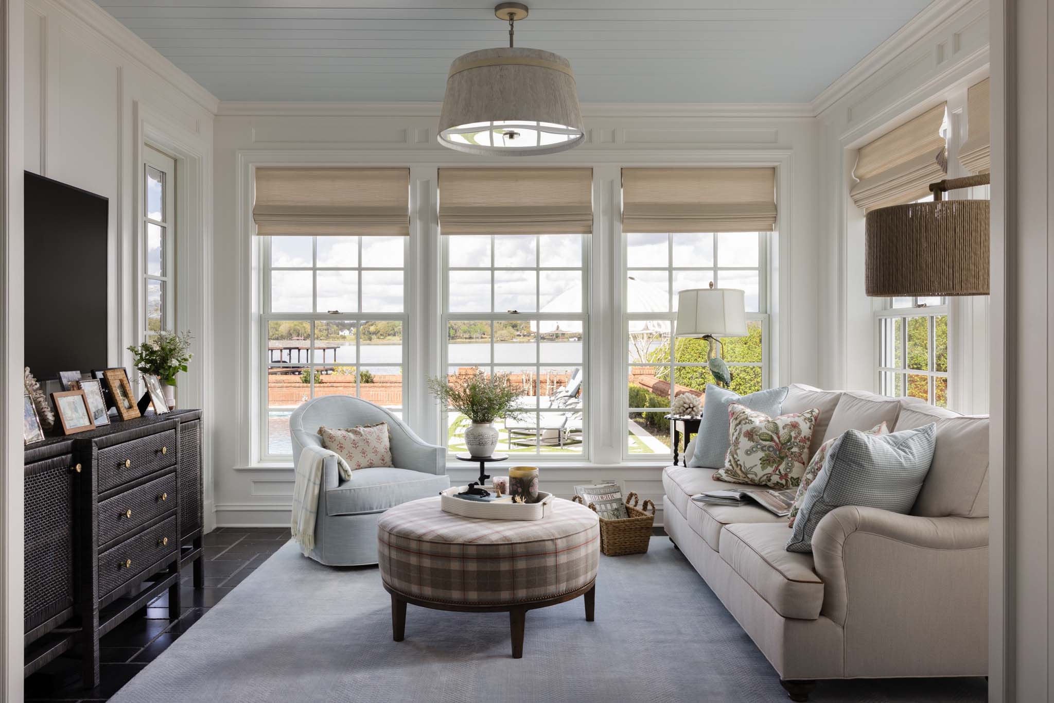 English country sunroom with custom furnishings, blue tongue-and-groove ceiling and lake views