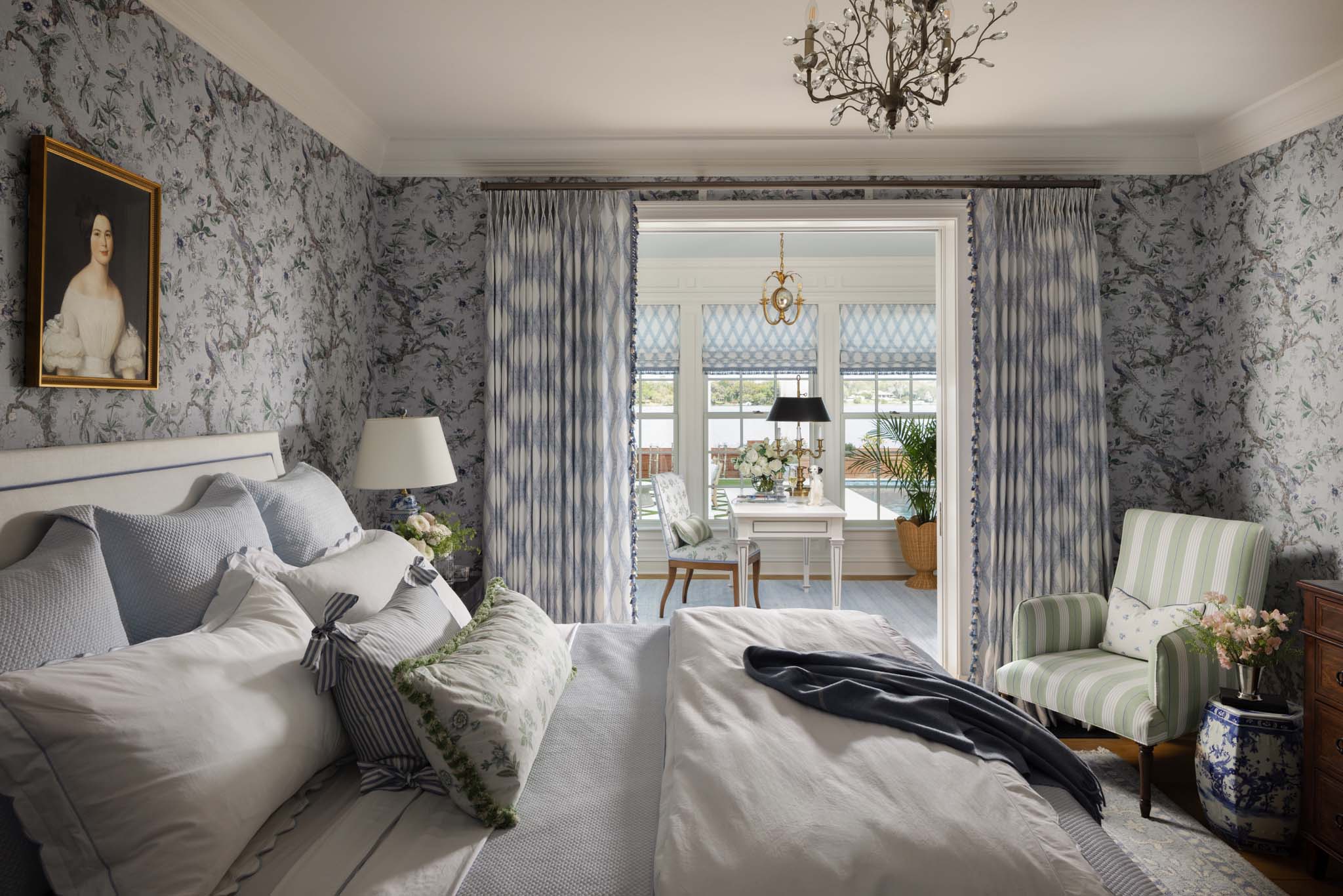 Blue and white English country primary bedroom with botanical wallpaper and custom drapery