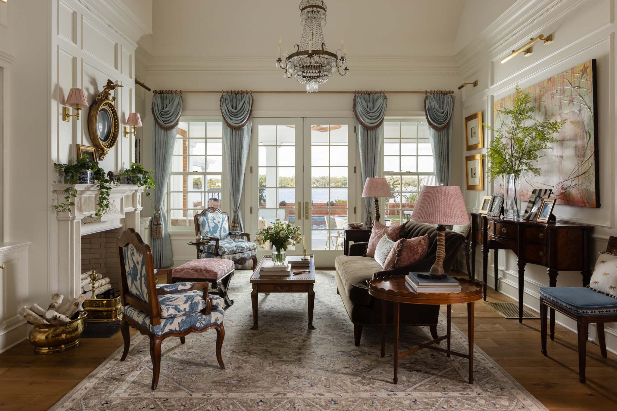 Traditional English country living room with fireplace and lake view